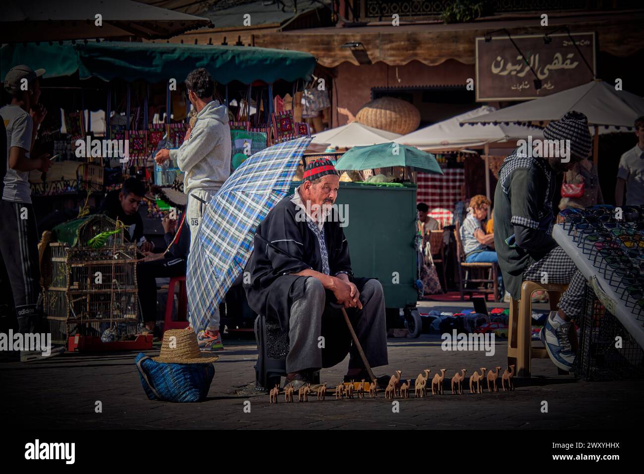 Un vecchio di origine marocchina con un ombrello che protegge dal sole Foto Stock