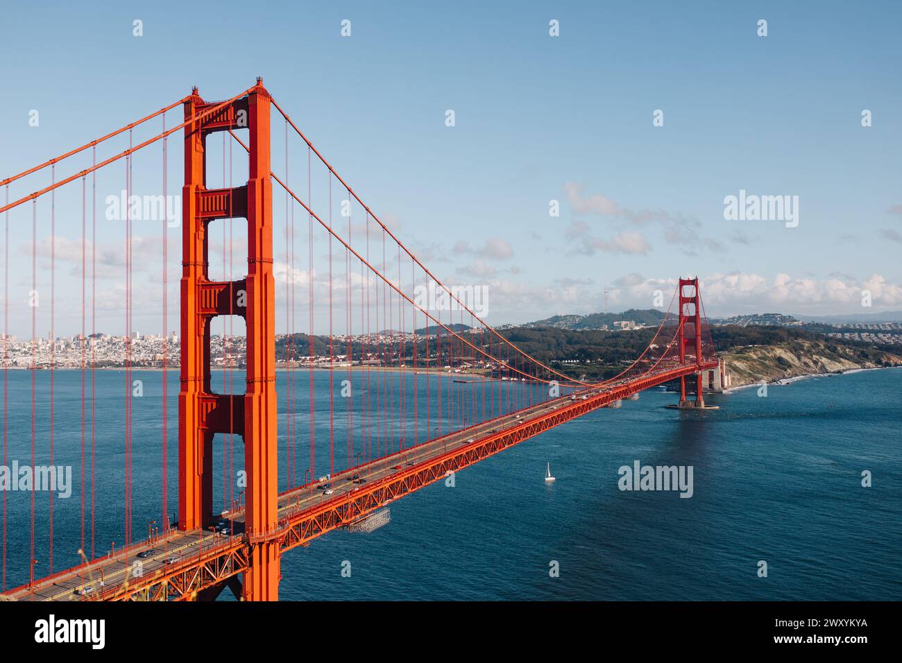 Una limpida giornata primaverile offre una vista mozzafiato del Golden Gate Bridge con lo skyline di San Francisco e le barche a vela che punteggiano la baia Foto Stock