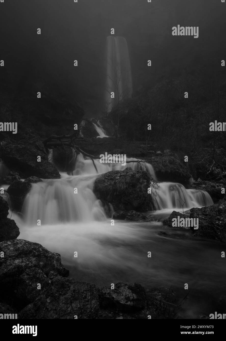 La cascata del Rio Mundo emerge come uno spettro spettrale, le sue acque sono sfocate di seta in mezzo al paesaggio ombroso Foto Stock