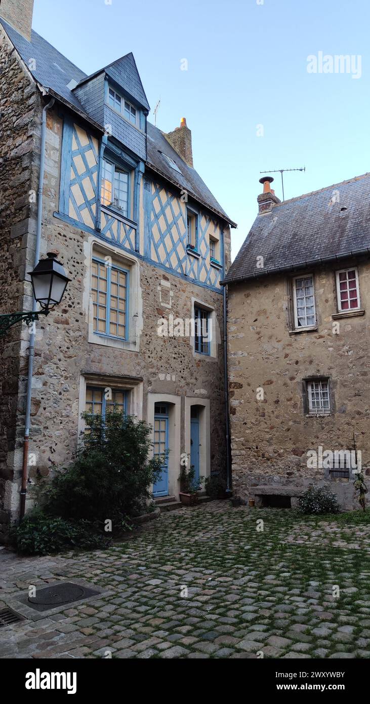 Vicoli pittoreschi della città vecchia di le Mans in Francia, cortile interno in vecchio stile, case in pietra con porte e finestre in legno blu. Foto Stock