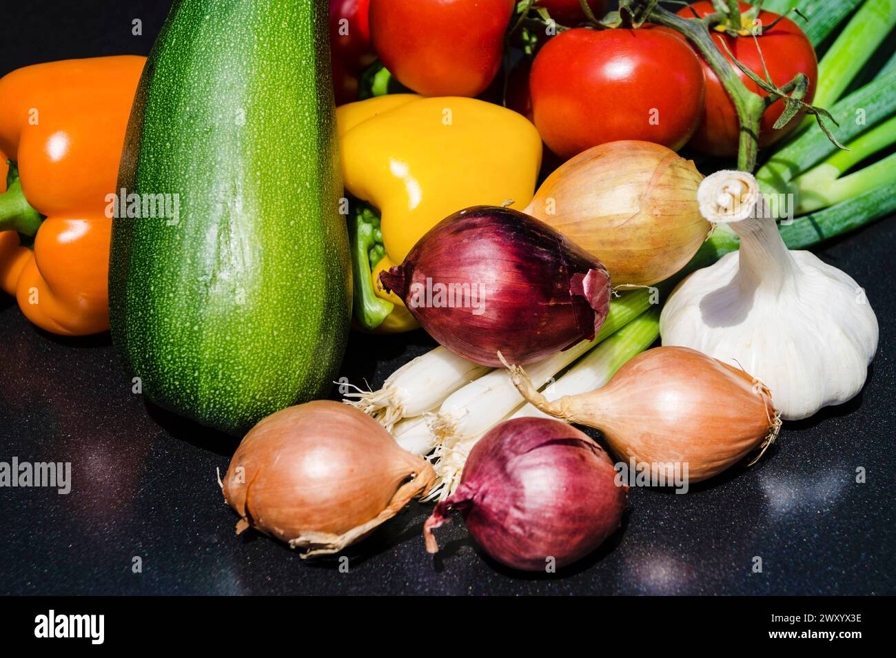 Verdure raccolte dall'orto: Peperoni, porri, pomodori, zucchine, cipolle e aglio Foto Stock