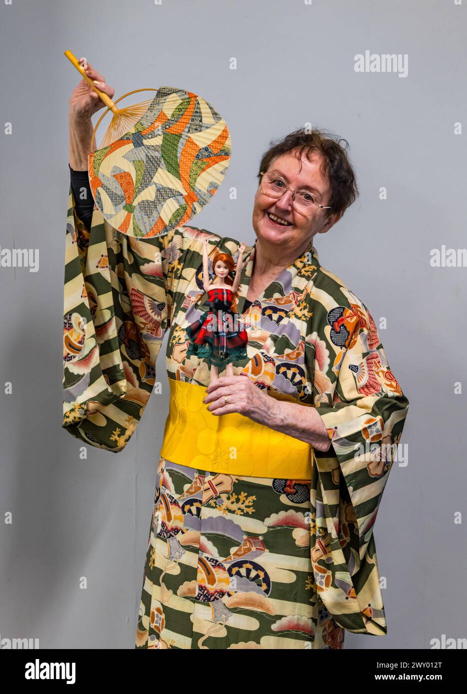 Central Library, Edimburgo, Scozia, Regno Unito, 03 aprile 2024, la mostra Dance Around the World del Traditional Dance Forum of Scotland e le biblioteche della città di Edimburgo per il Pomegranates Festival si apre oggi, con articoli provenienti da oltre 20 paesi. Nella foto: L'artista scozzese di danza e storica Agnes Ness (81 anni), che ha co-curato la mostra, con a Tartan Barbie Doll di Alison HARM di Psychomoda Sustainable Tartan. Crediti: Sally Anderson/Alamy Live News Foto Stock