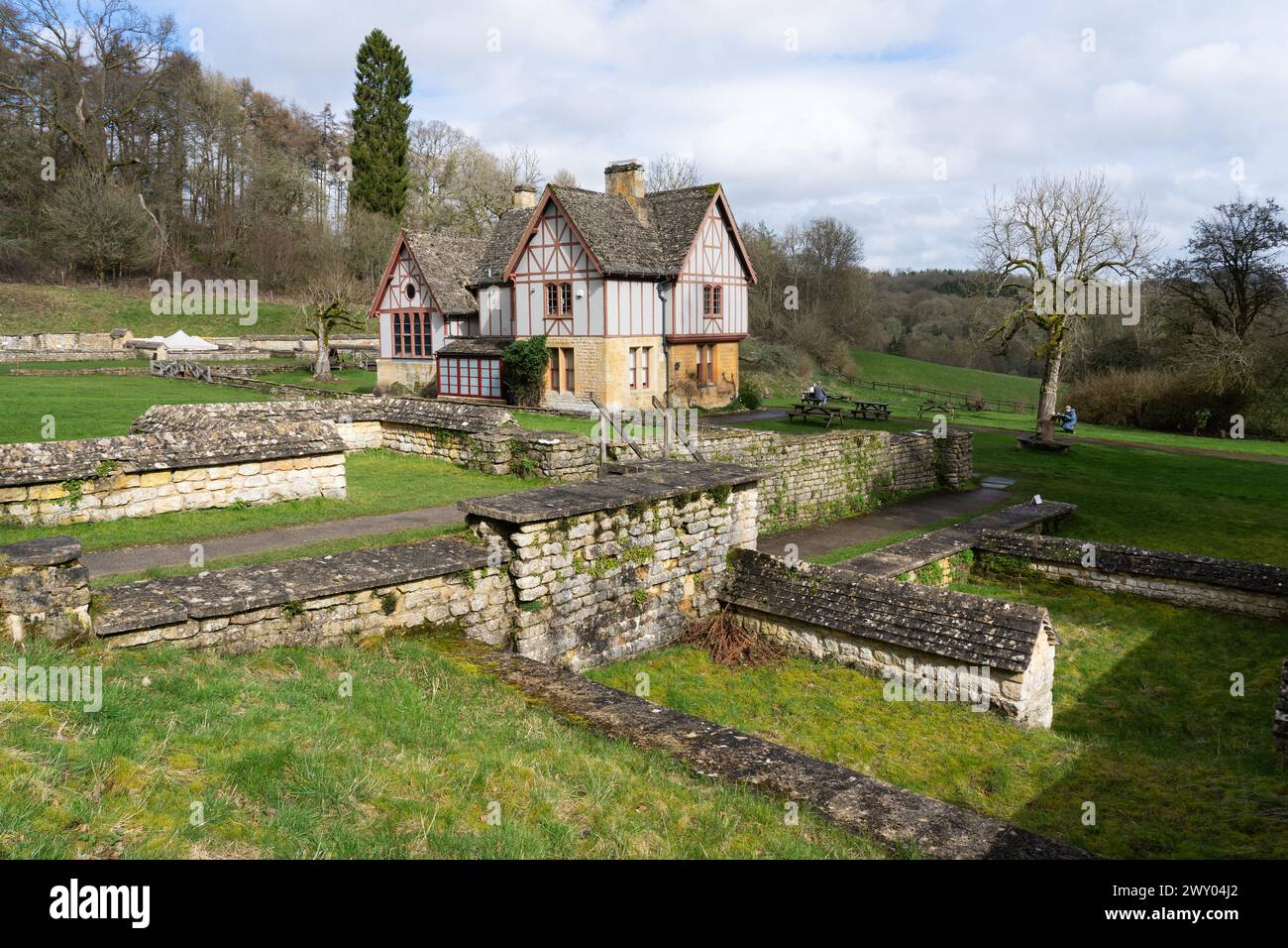 L'ala sud e i resti in rovina di Chedworth Roman Villa con la loggia vittoriana e l'edificio del museo sullo sfondo, Gloucestershire, Inghilterra Foto Stock