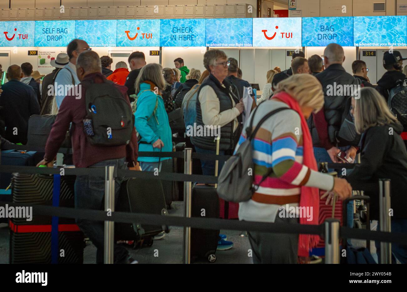 I turisti aspettano di fare il check-in con Tui Airlines al Terminal Nord, Aeroporto di gatwick, Londra, Regno Unito. Foto Stock