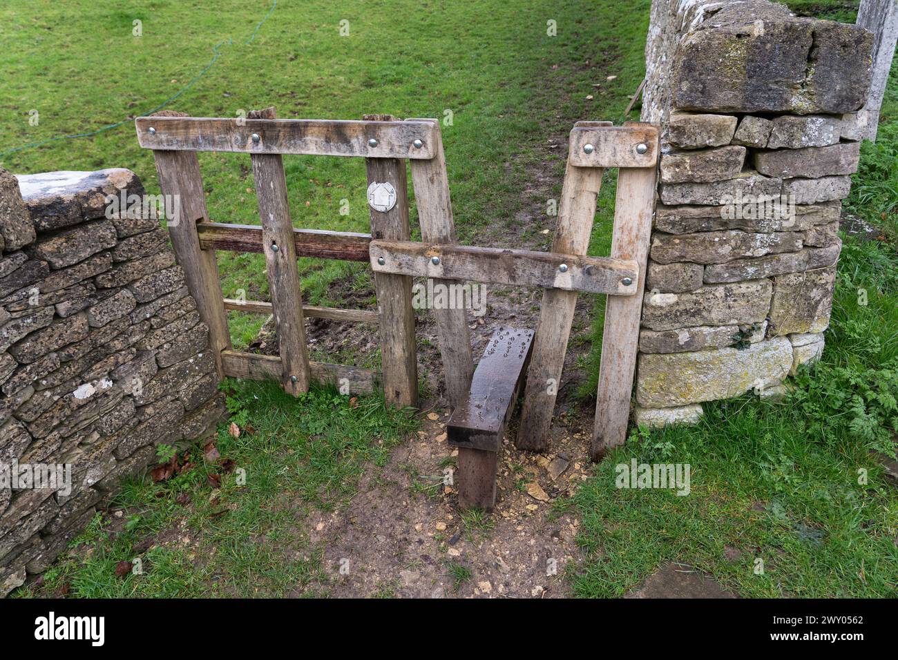 Uno stile tradizionale in legno nel villaggio inglese di Chedworth, che permette alle persone di accedere a un campo, ma non agli animali. Inghilterra, Regno Unito Foto Stock