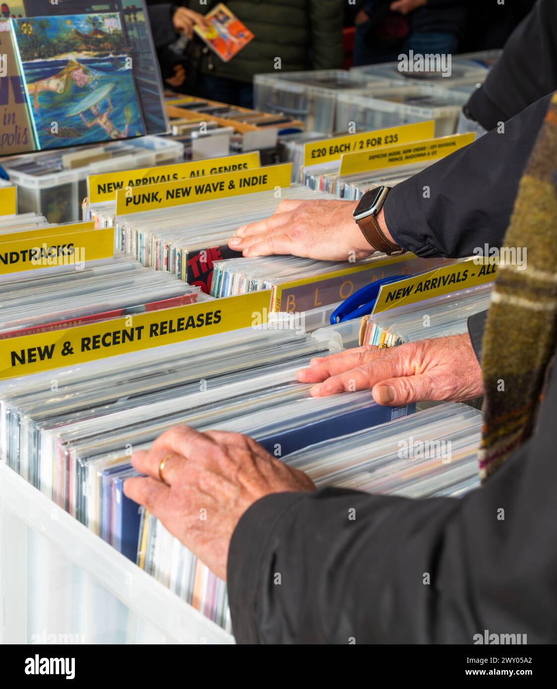 Le mani degli uomini esplorano i dischi in vinile alla fiera record di un appassionato a Totnes, Devon, Regno Unito. Foto Stock