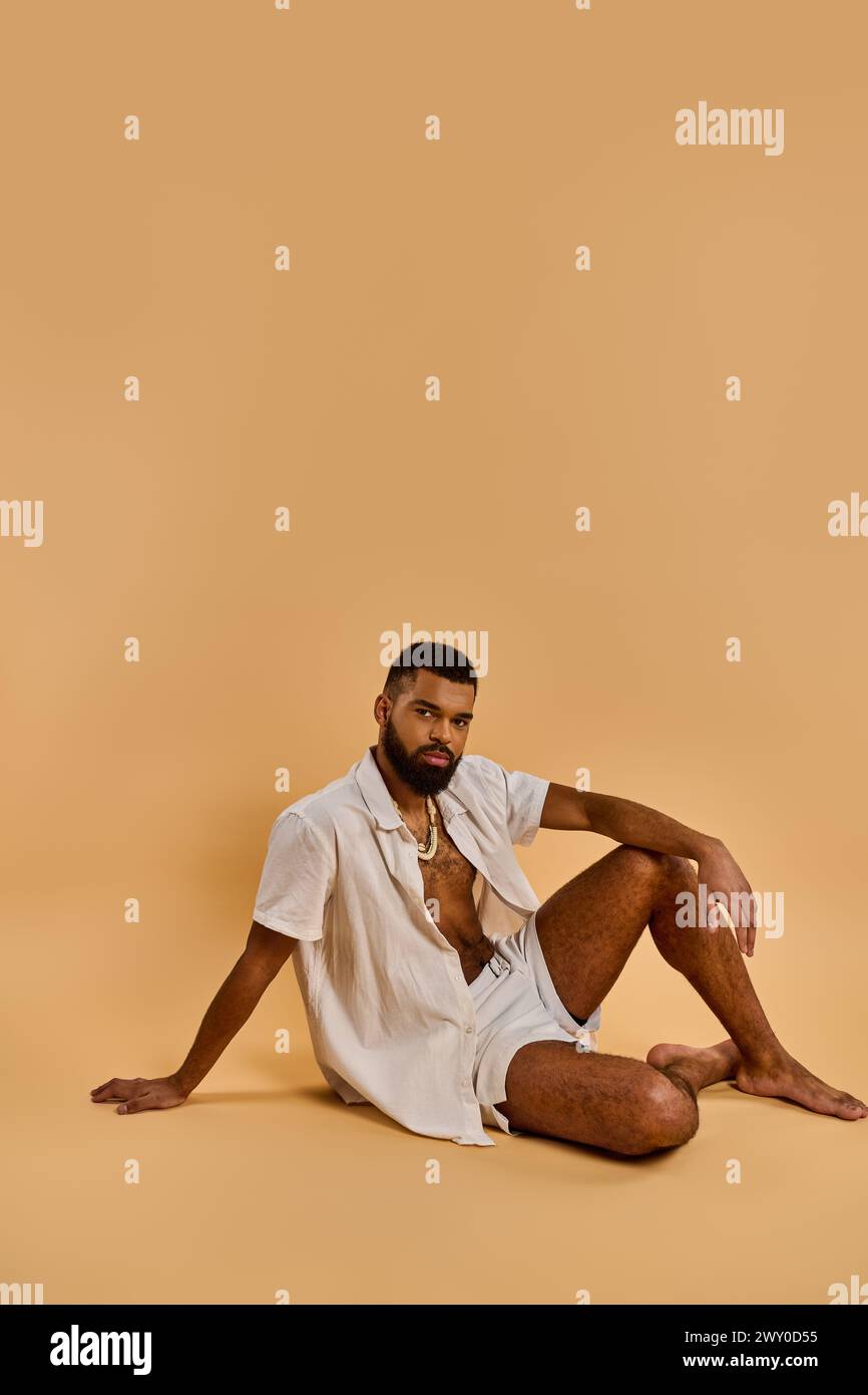 Un uomo si siede a terra con le gambe incrociate, nel profondo del pensiero, il suo sguardo si è concentrato davanti come se si riflettesse sul viaggio da percorrere. Foto Stock