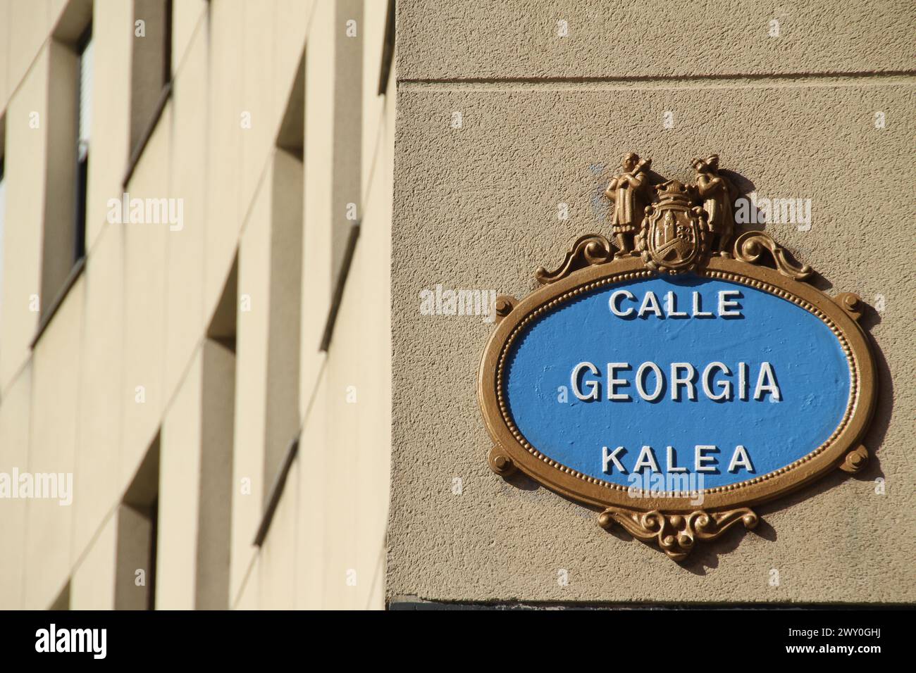 Un'antica placca blu, applicata alla parete esterna di un edificio, con un bordo ornato e una superficie ruvida Foto Stock