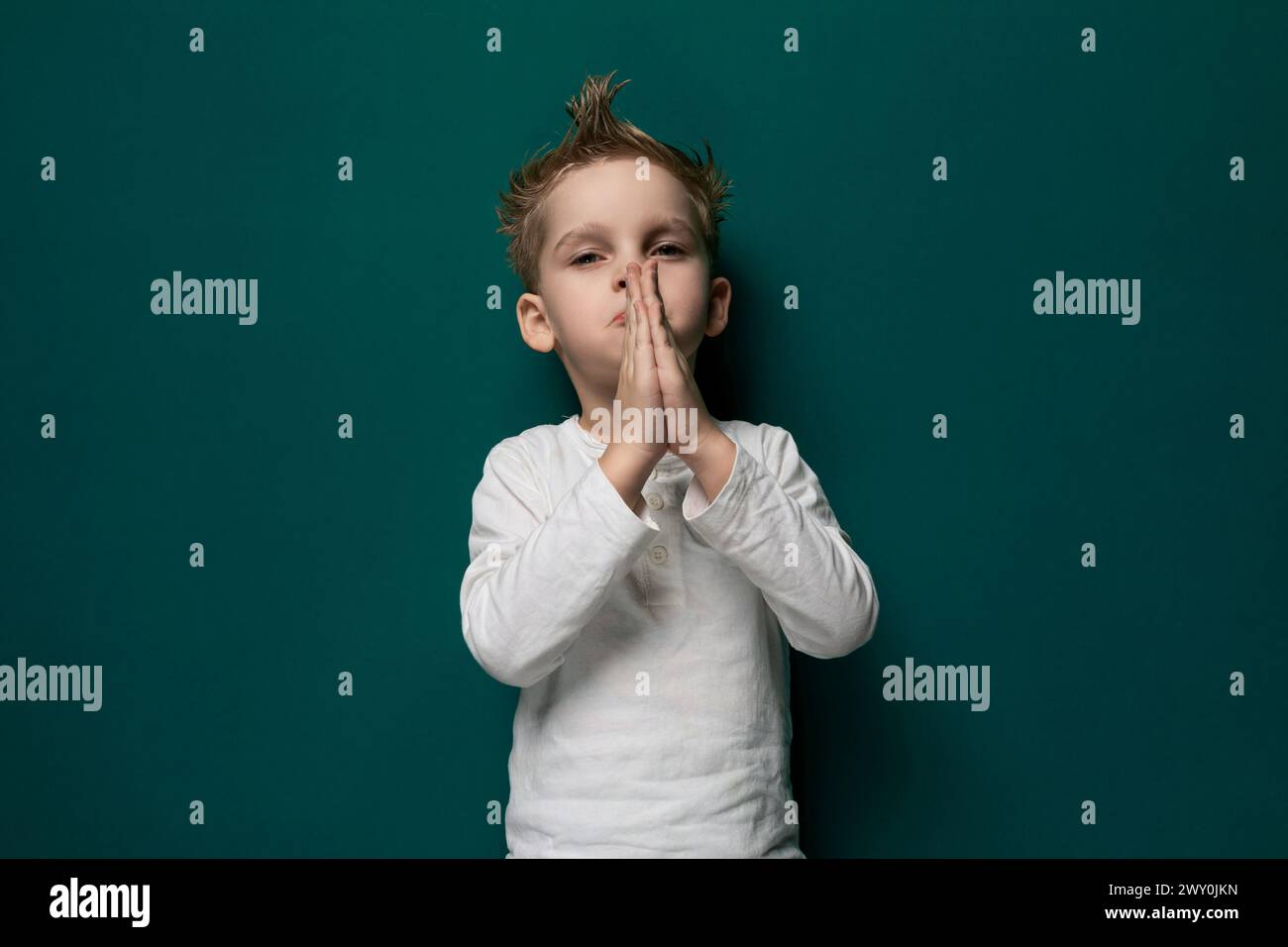 Young Boy che copre la bocca con le mani Foto Stock