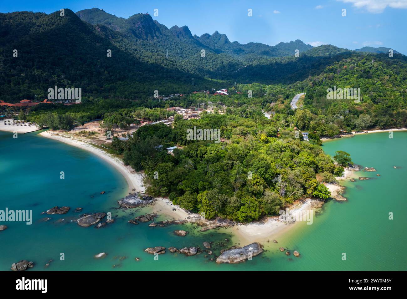 Un bellissimo oceano blu con una costa verde e una montagna sullo sfondo. Pantai Kok, Langkawi, Malesia Foto Stock