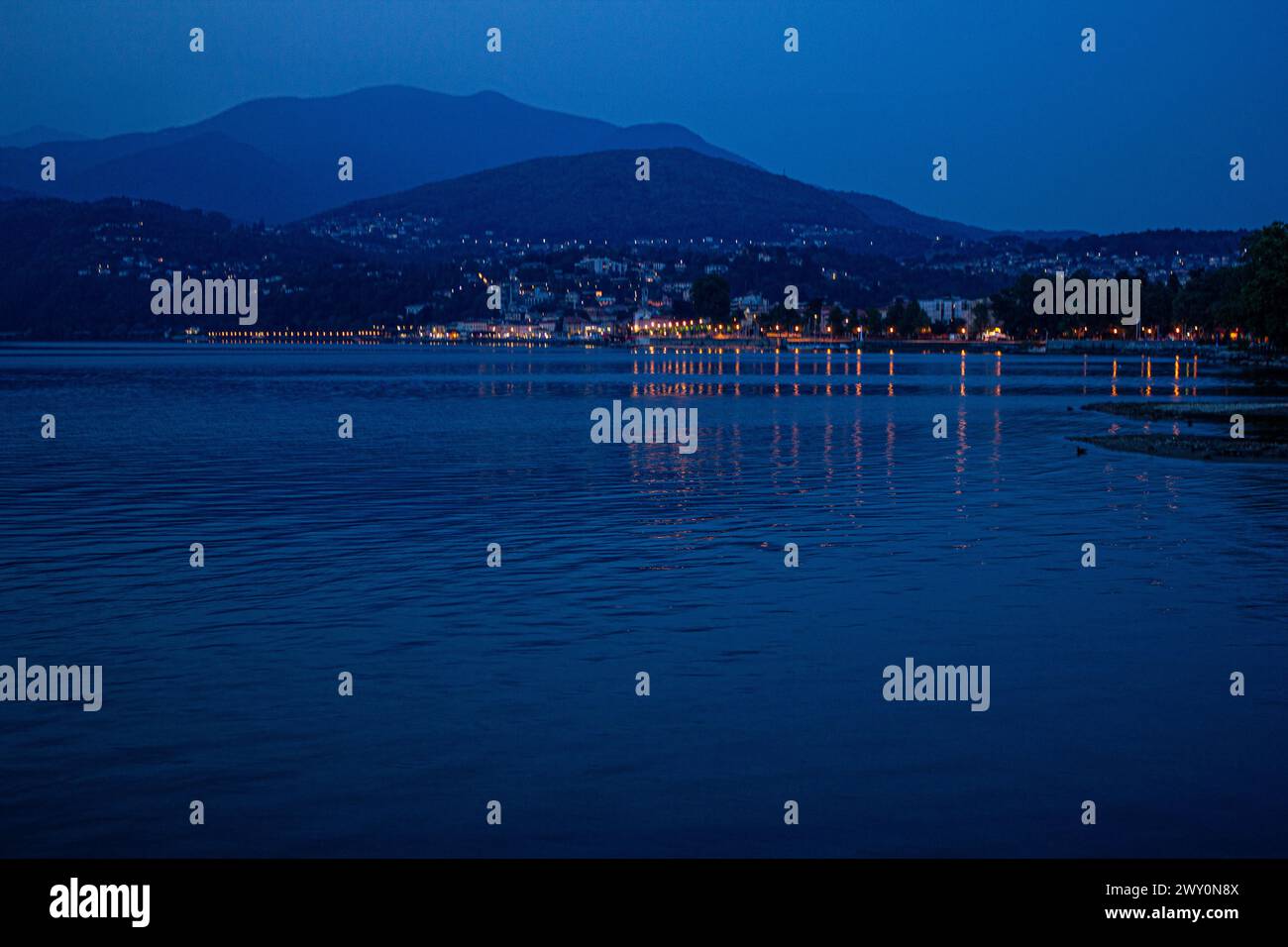 Le luci notturne di Luino si riflettono sul lago Foto Stock