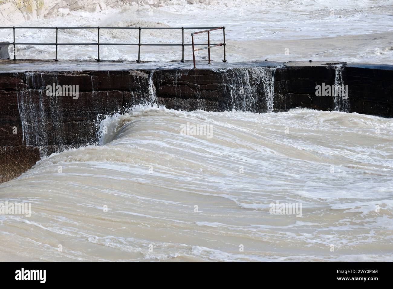 mare agitato clima ventoso seaford coastal splash point area grandi onde nella fredda stagione primaverile potenti battaglie marittime con barriere costiere e scogliere Foto Stock