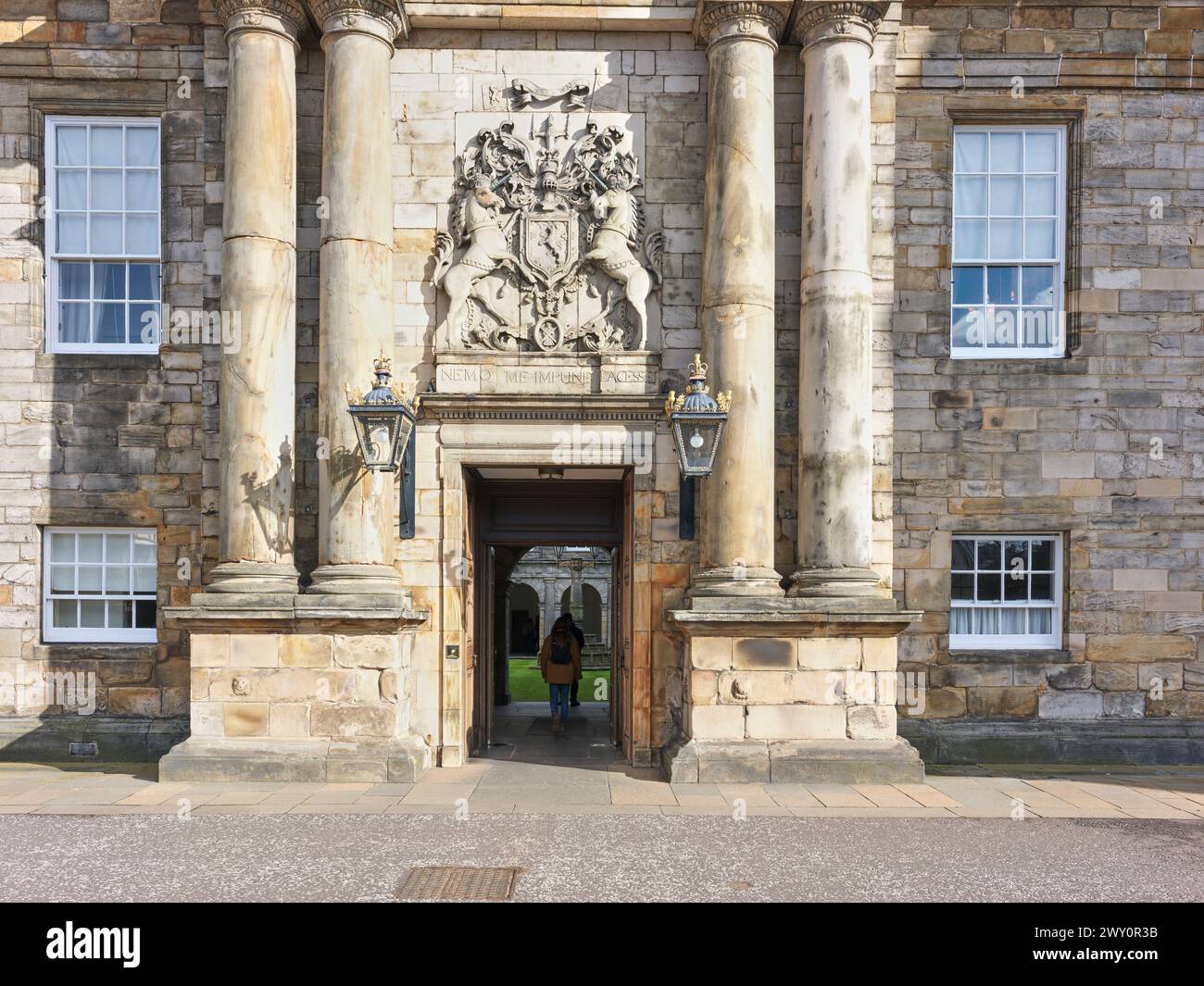Visitatore all'ingresso del cortile di Holyrood Palace (holyroodhouse), Edimburgo, casa del monarca britannico in Scozia. Foto Stock