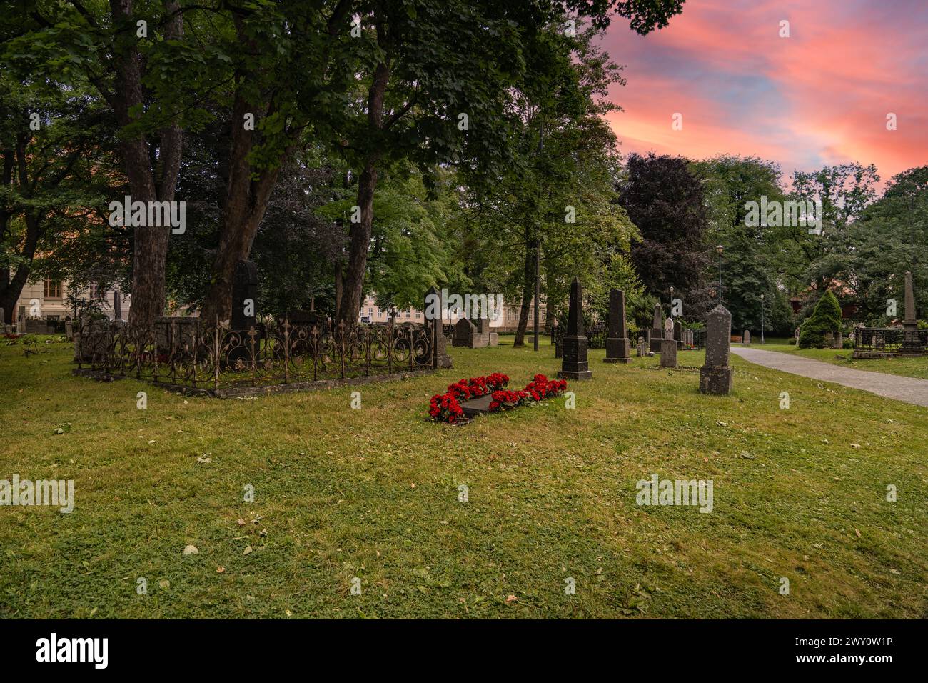 Crepuscolo al cimitero della cattedrale di Nidaros a Trondheim, Norvegia. Serena serata presso il luogo di sepoltura con il cielo del tramonto che proietta calde sfumature sul sito storico Foto Stock