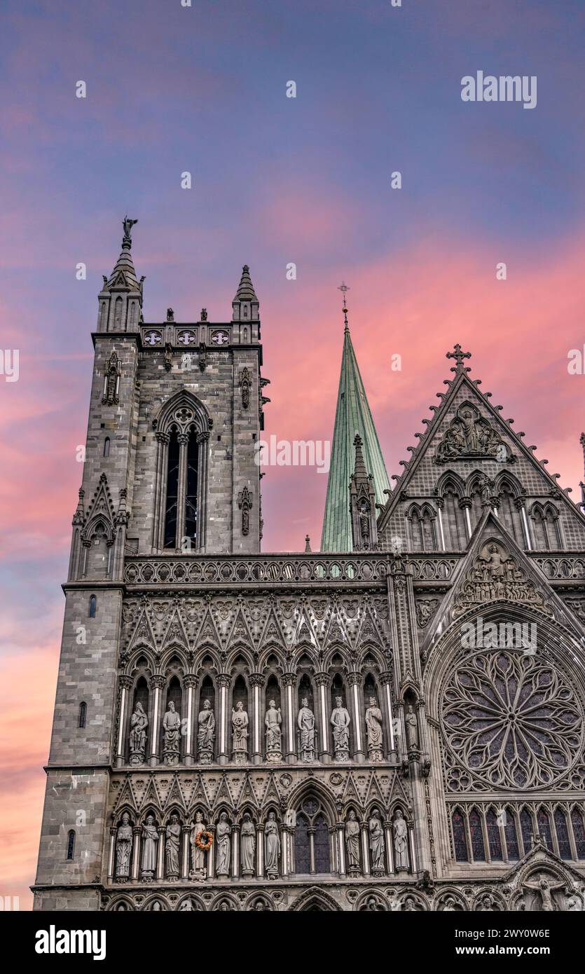 Tramonto sulla facciata della cattedrale di Nidaros, sul campanile e sulla guglia. La facciata delle cattedrali si staglia contro un vivido cielo estivo serale a Trondheim in Norvegia Foto Stock