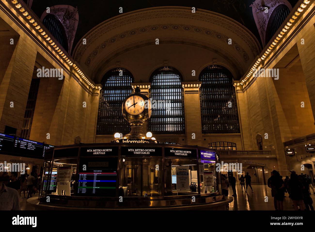 New York, NY - 7 agosto 2023: I pendolari passano l'orologio al Grand Central Terminal sulla 42a strada a Manhattan. Stazione ferroviaria urbana trafficata. Foto Stock