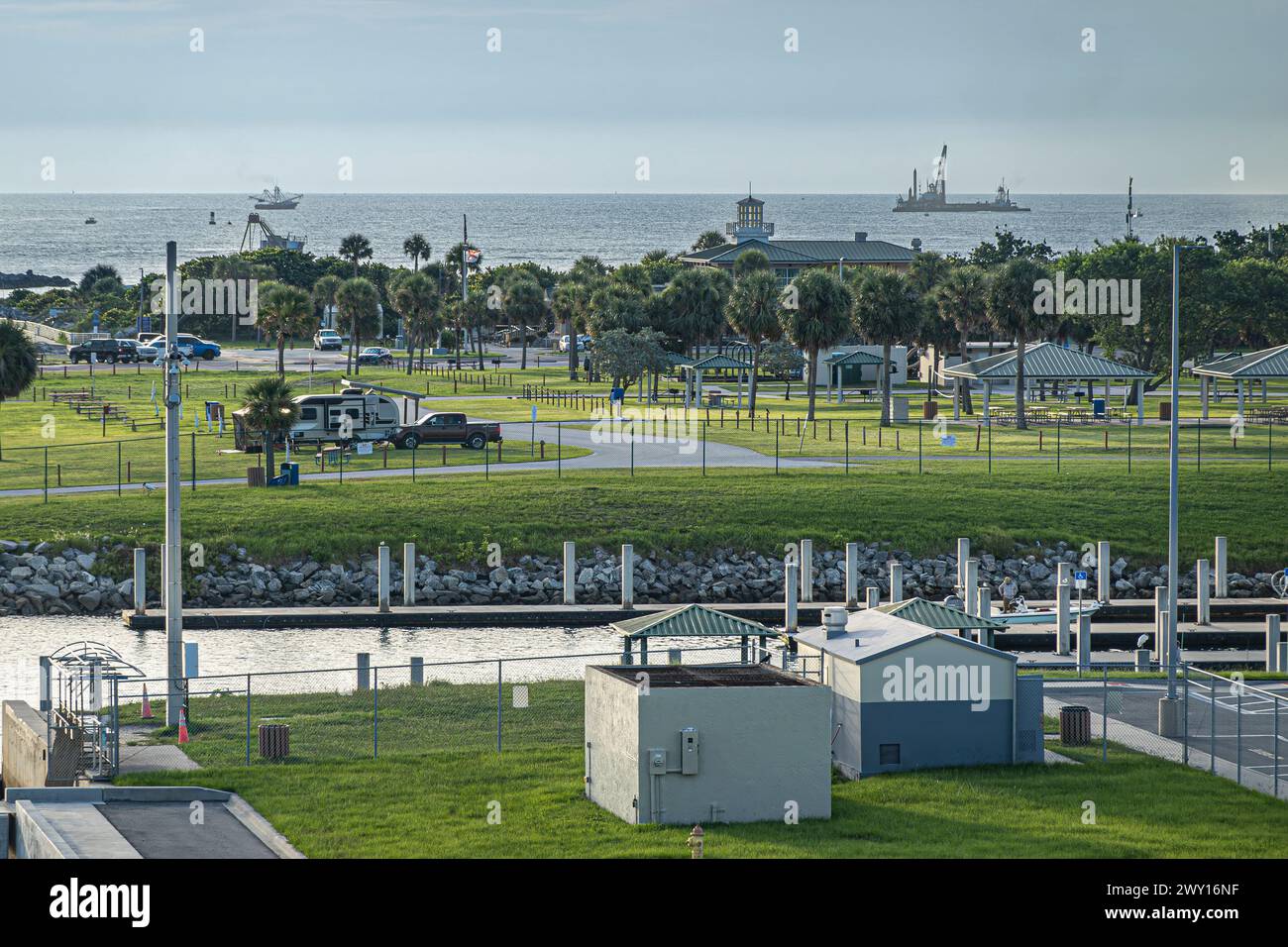 Port Canaveral, Florida, Stati Uniti - 30 luglio 2023: Parcheggio verde e area picnic con peschereccio sull'Oceano Atlantico all'orizzonte Foto Stock