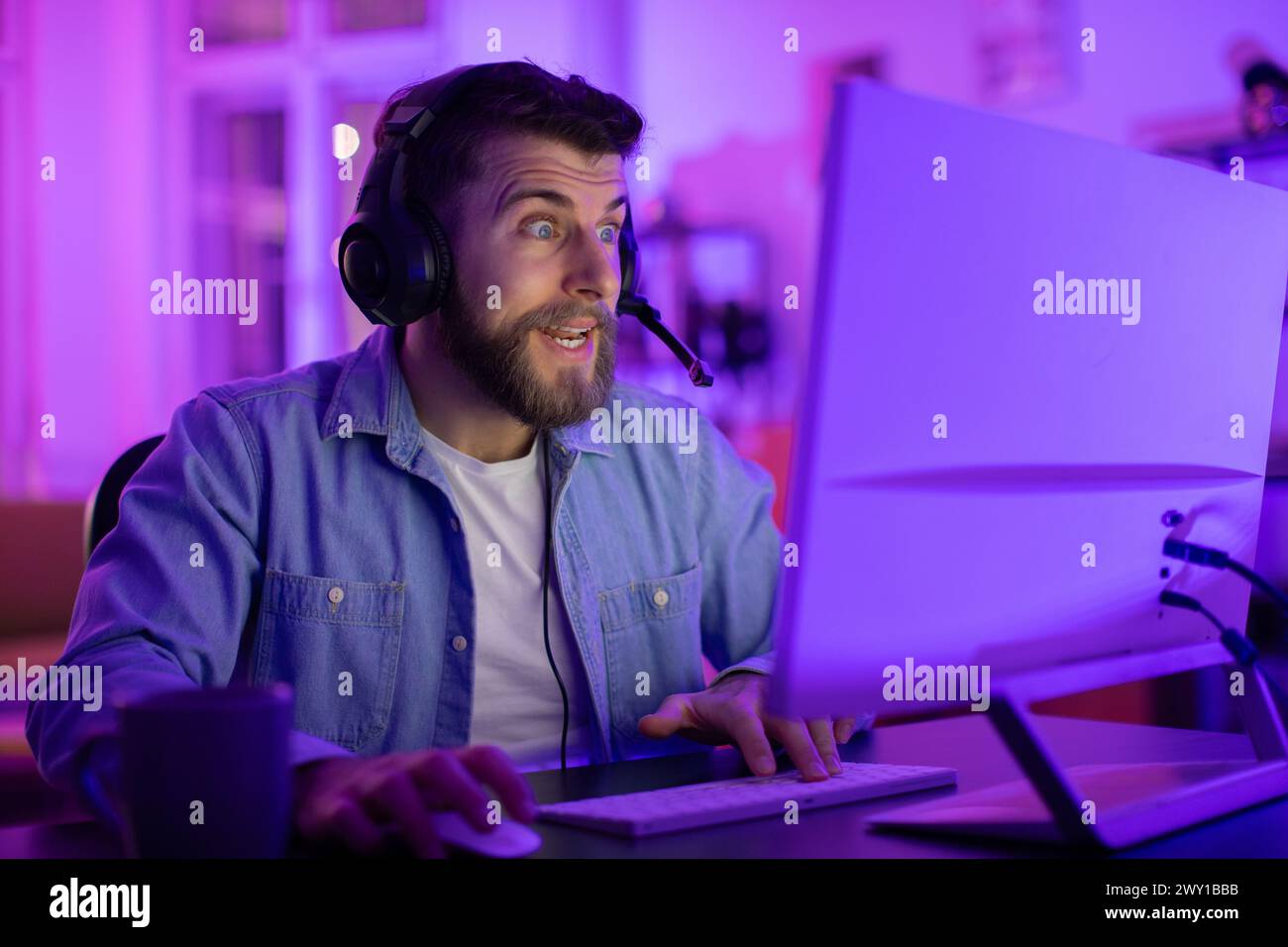 Uomo intensamente concentrato sullo schermo del computer a casa Foto Stock