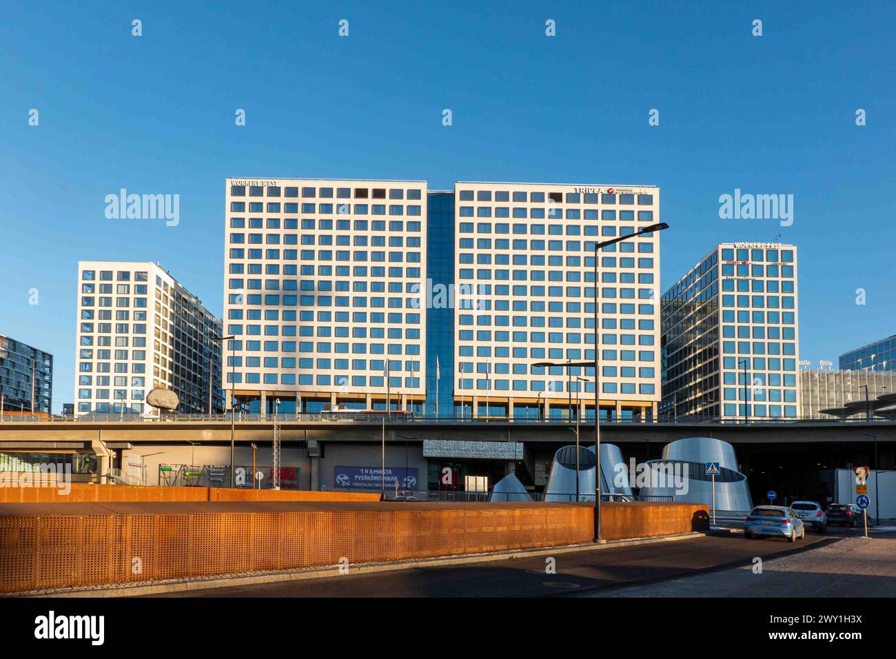 Complesso Tripla di hub dei trasporti, hotel, edifici di uffici e centro commerciale al sole della mattina presto nel quartiere Keski-Pasila di Helsinki, Finlandia Foto Stock