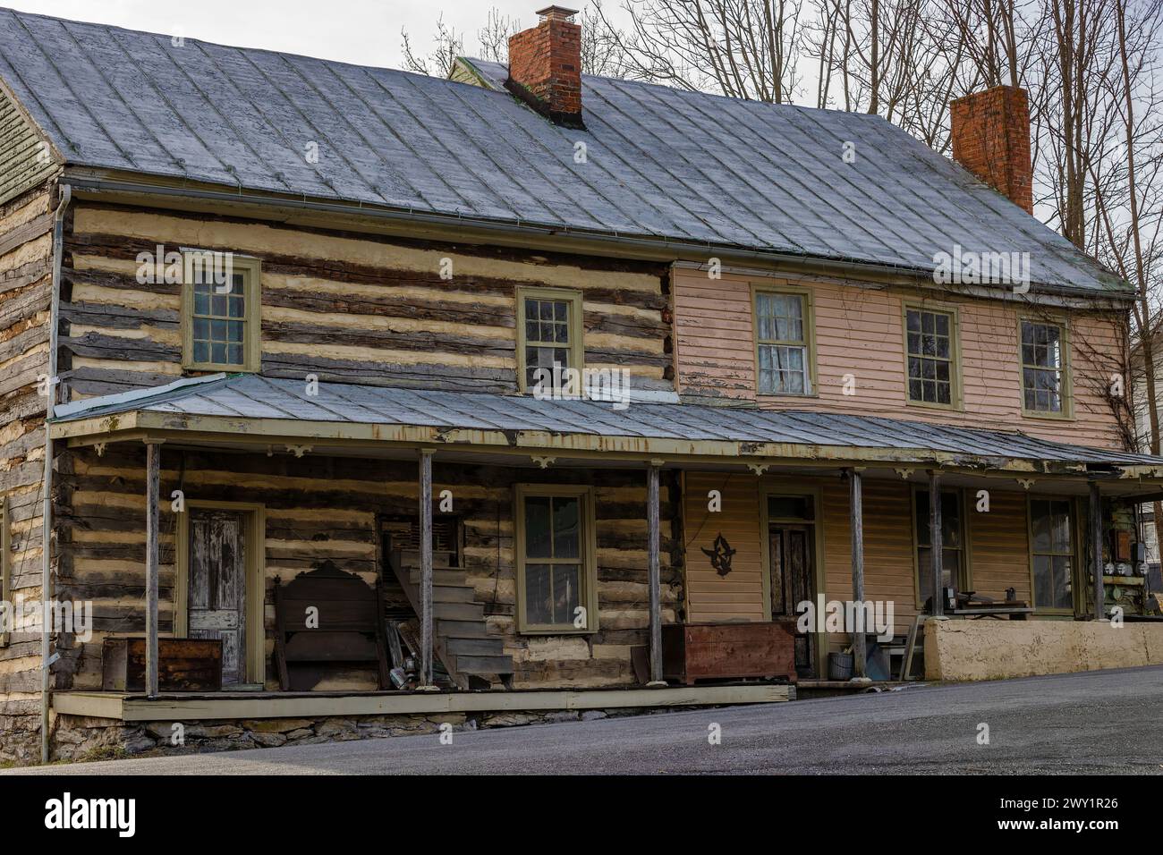 Staunton, Virginia, USA - 25 febbraio 2024: Una volta una capanna a due piani con una nuova aggiunta sembra essere abbandonata nella Virginia rurale vicino a Staunton. Foto Stock