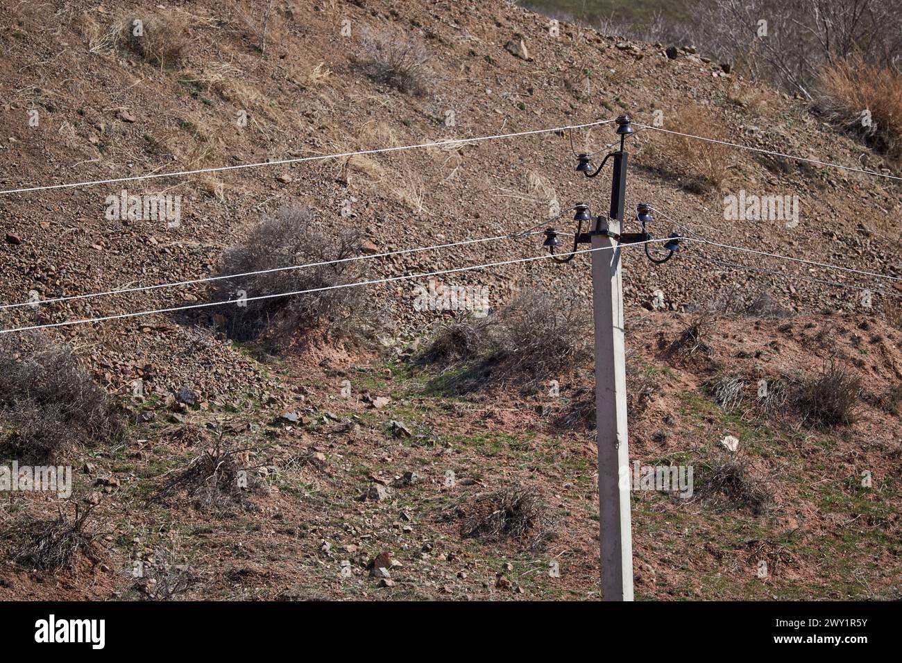 Vecchia linea elettrica con piccoli flussi di potenza a bassi livelli di tensione domestica in campagna. trasmissione elettrica, montante in calcestruzzo, trasporto di elettricità Foto Stock