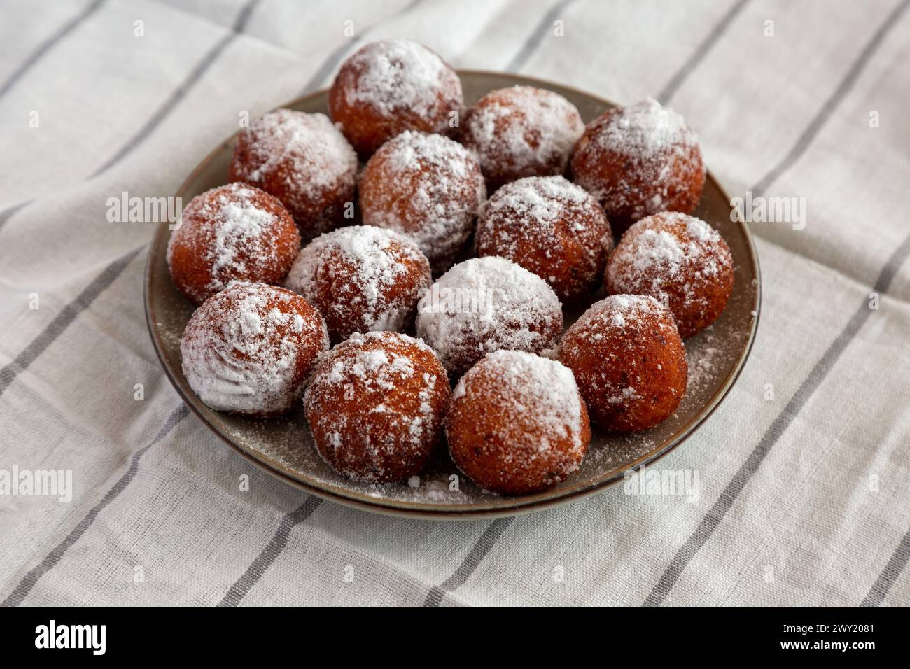 Ciambelle fritte fatte in casa con zucchero a velo su un piatto, vista laterale. Foto Stock