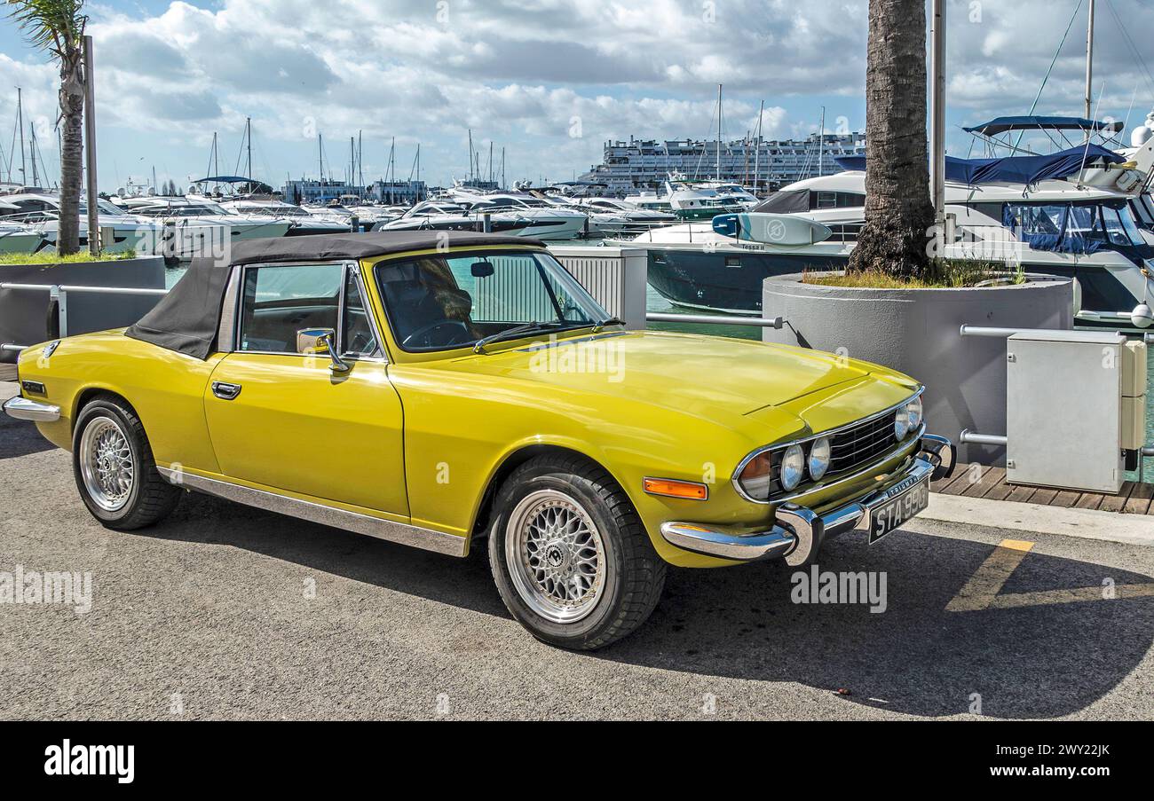 Una Triumph Stag a due posti gialla, con capote, sul molo di Vilamoua, Portogallo. Prodotto dalla British Leyland. Foto Stock