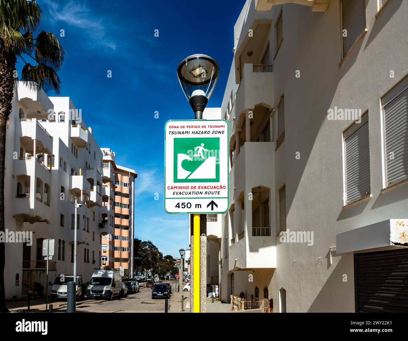 Un cartello indicante una zona a rischio di tsunami è esposto in modo prominente vicino alla costa di Quarteira, Portogallo. Foto Stock