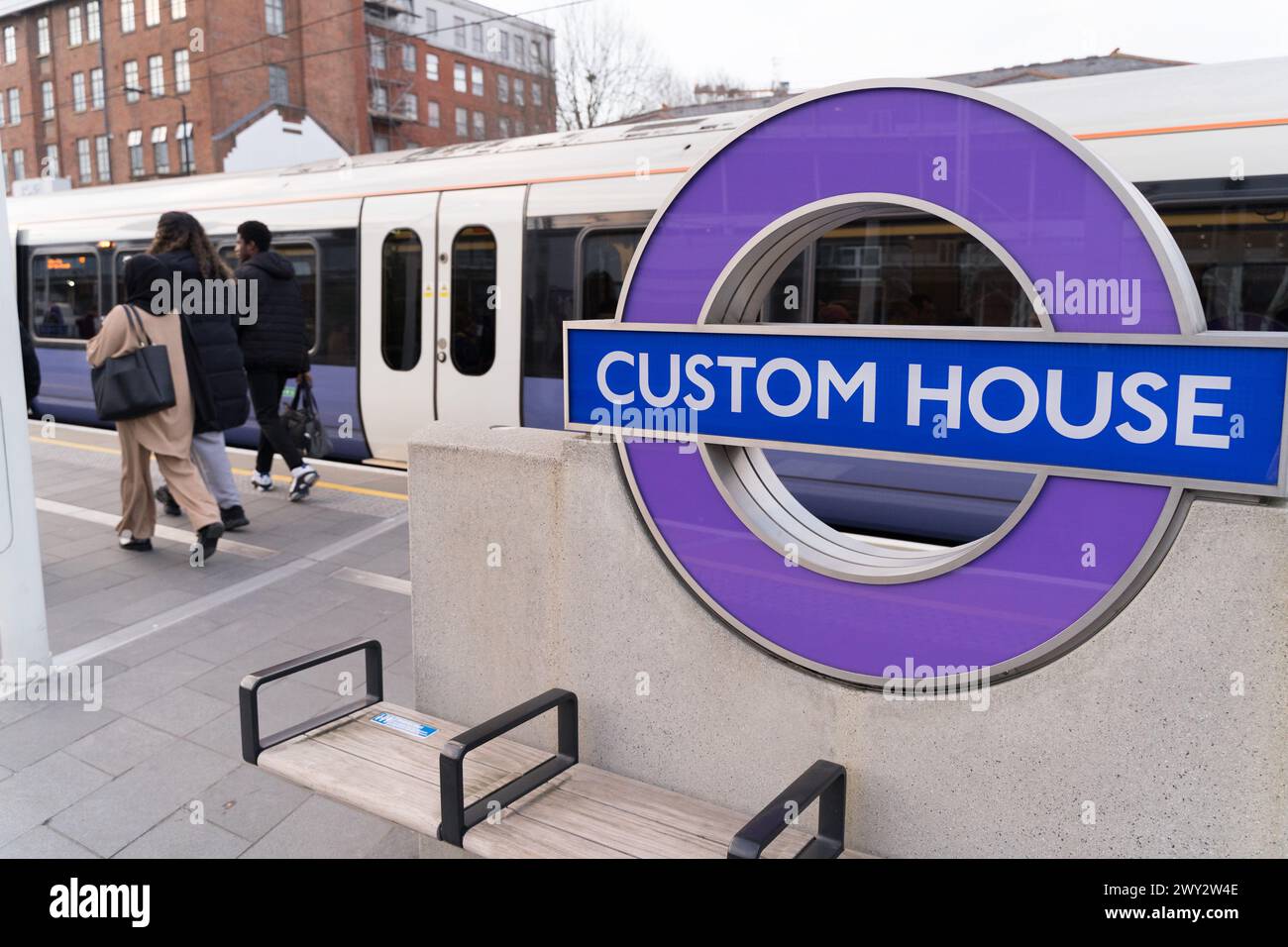 I passeggeri scendono dalla Elizabeth line alla stazione della metropolitana di Custom House con il logo della rotonda TFL su Planform, Londra, Inghilterra Foto Stock