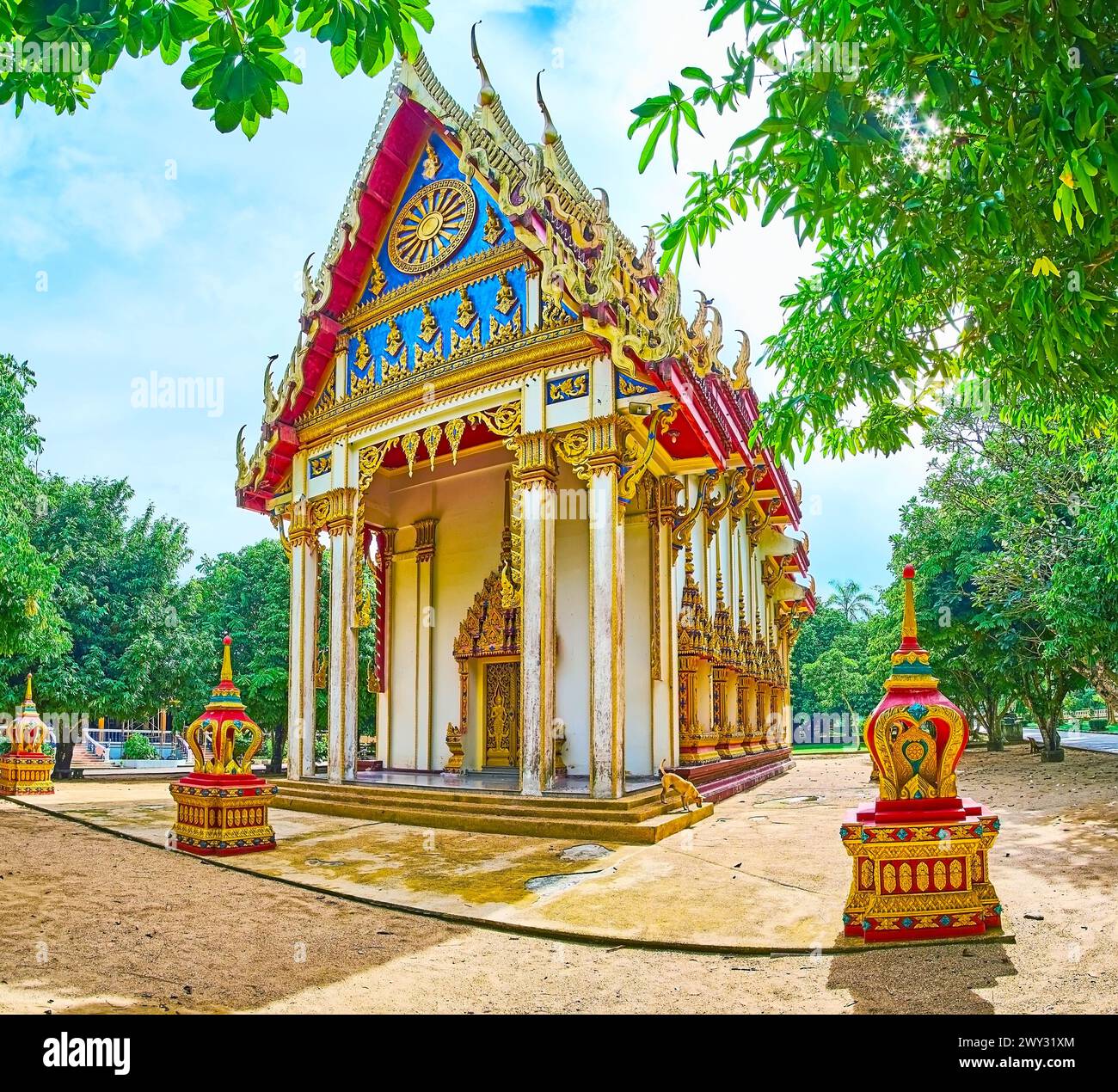 Lo stupefacente Ubosot del tempio Wat Suwan Kuha con decorazioni scolpite e scolpite, tetto multi-stanco e tavole da bargeboard in legno dorato con serpenti Naga, Phan Foto Stock
