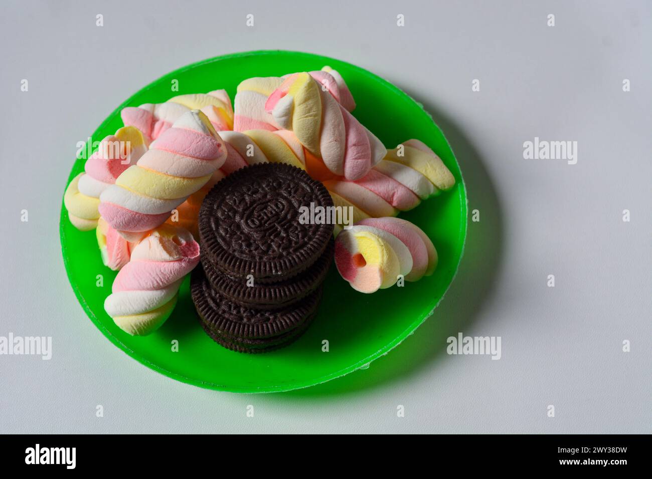 11 maggio 2023, Wonosobo Indonesia: Foto di oreos e marshmallow su un piccolo piatto verde su sfondo bianco. Foto Stock