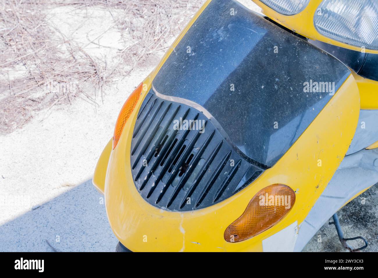 Griglia anteriore e luci di uno scooter giallo parcheggiato al sole in Corea del Sud Foto Stock
