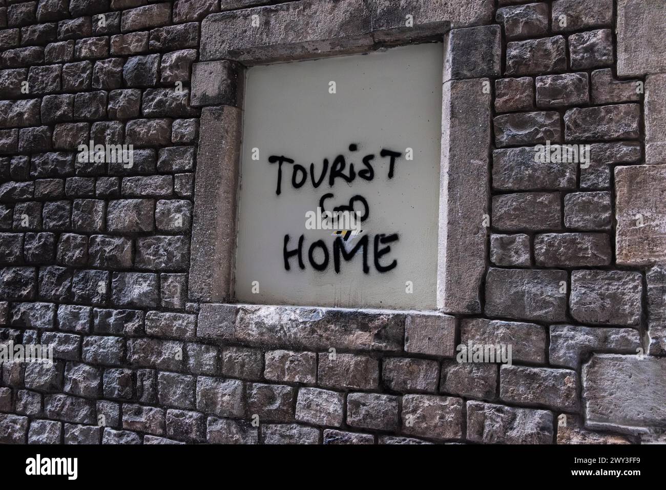 I turisti vanno a casa con le scritte su un muro a Barcellona, Spagna Foto Stock