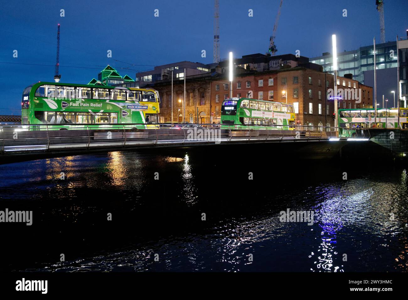 Gli autobus attraversano il fiume Liffey di notte. Dublino, Irlanda Foto Stock