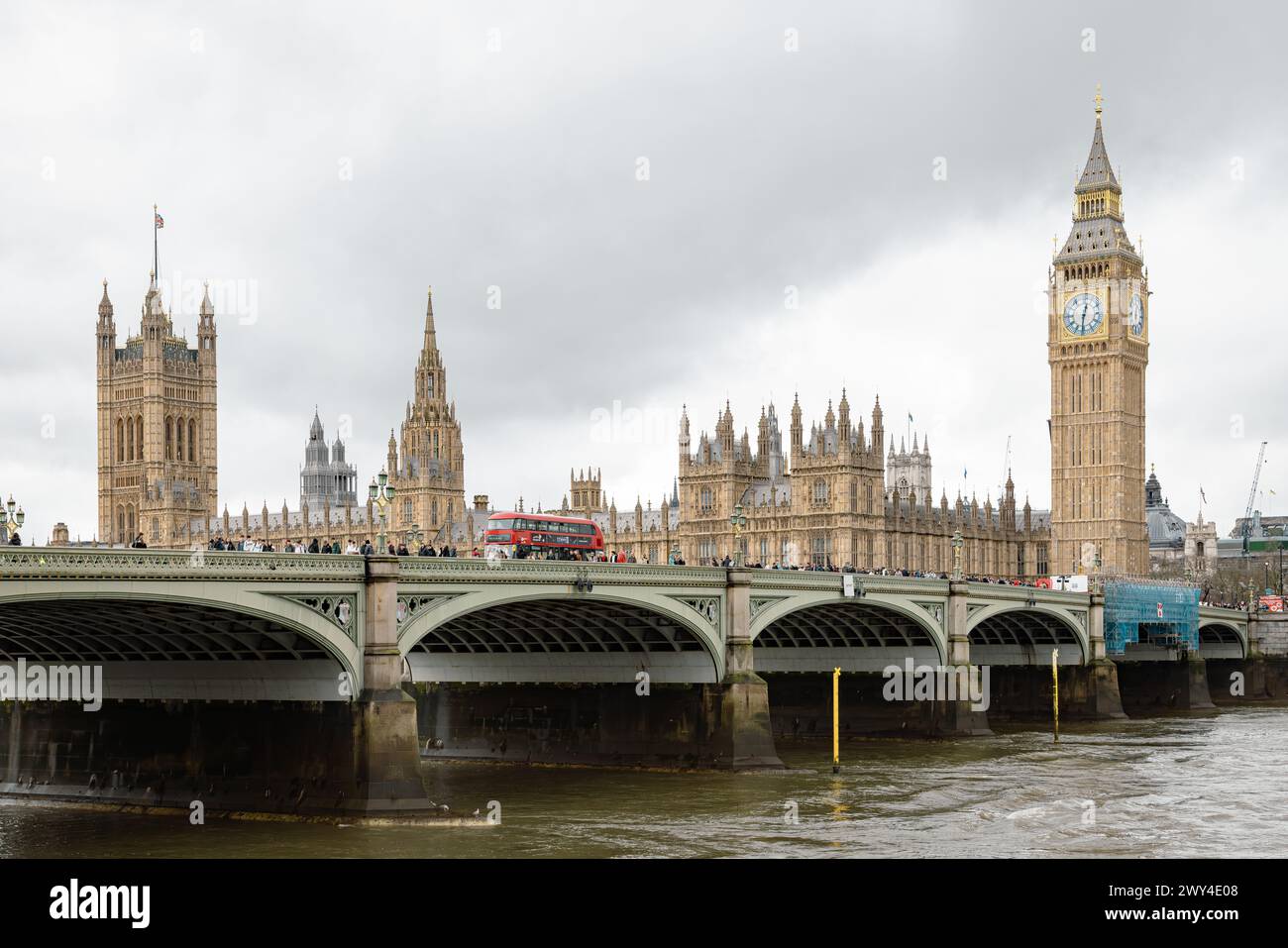 Un autobus rosso di Londra che attraversa il ponte di Westminster. Dietro di esso il Big Ben e le Houses of Parliament, un simbolo iconico della democrazia e del patrimonio britannico. Foto Stock