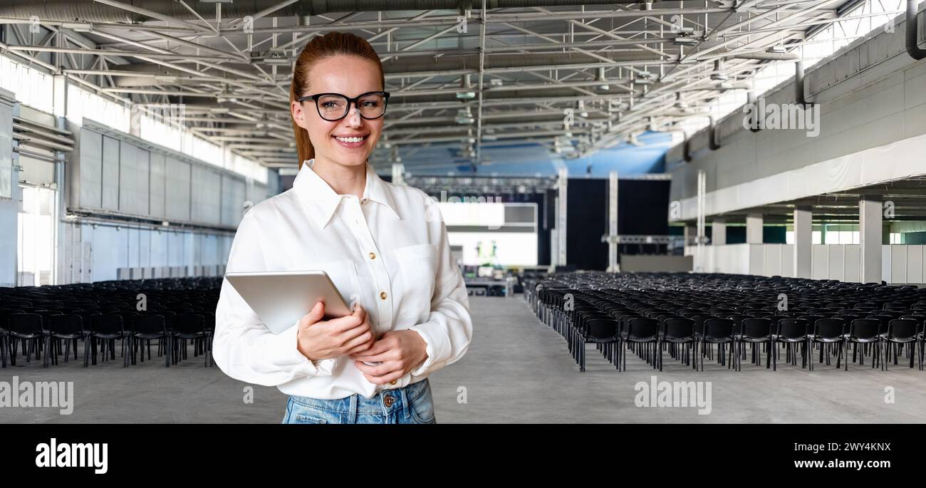 Donna d'affari e sala conferenze con sedie vuote e palco sfocato. Foto Stock