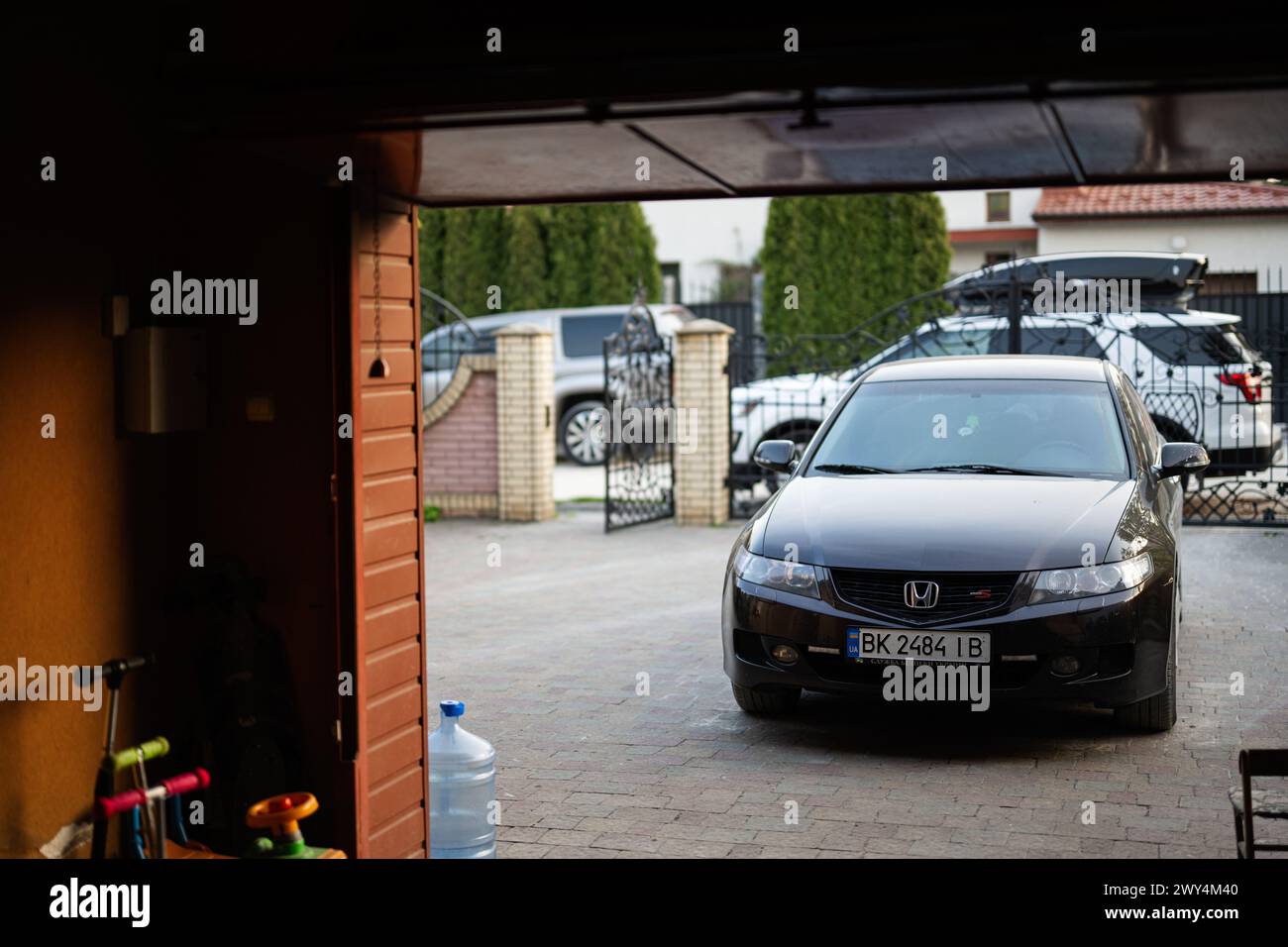 Ternopil, Ucraina- marzo 2023: Un'auto nera Honda Accord parcheggiata nel vialetto di una casa residenziale, pronta per una gita in famiglia o per gli spostamenti quotidiani. Foto Stock