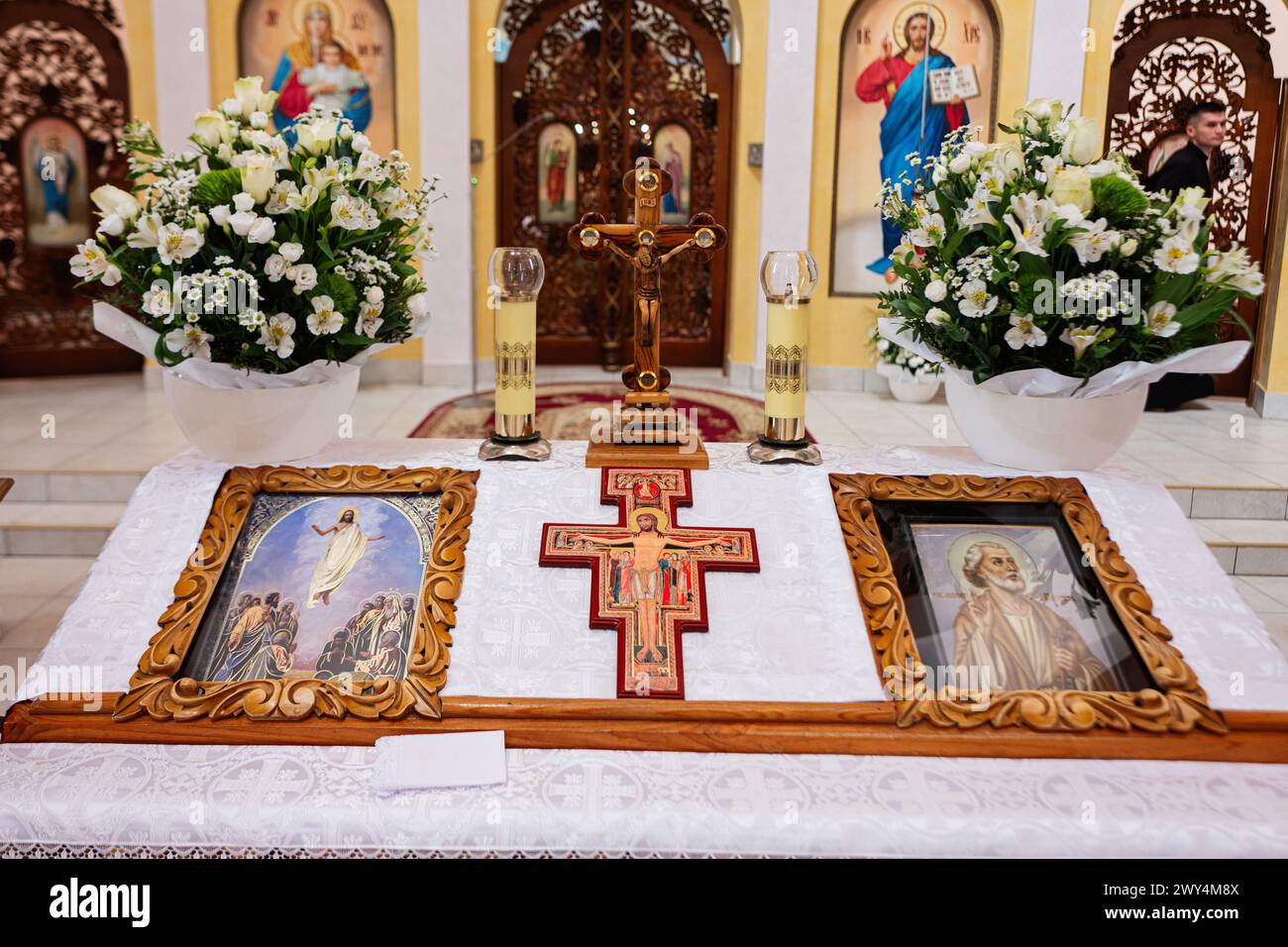 Ternopil, Ucraina - maggio 2023: Uno sguardo intimo su un altare della chiesa cristiana con icone religiose, una croce, lampade a candela e composizioni floreali durante Foto Stock