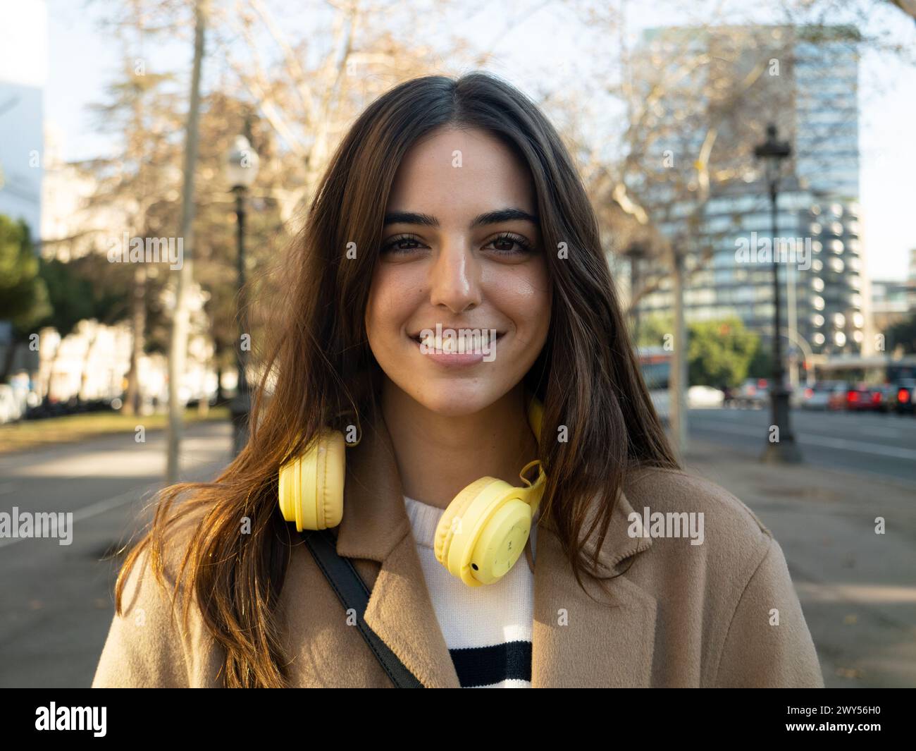 Ritratto di una giovane donna sorridente spensierata in una città. Ritratto di donna potenziata Foto Stock