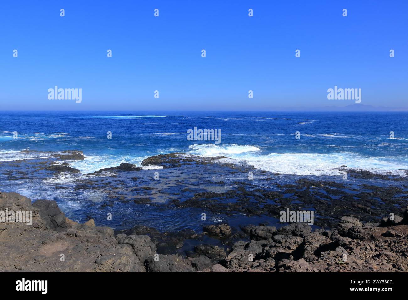 Onde tempestose si infrangono sulla spiaggia di pietra di Fuerteventura nel Parco naturale di Jandia Foto Stock