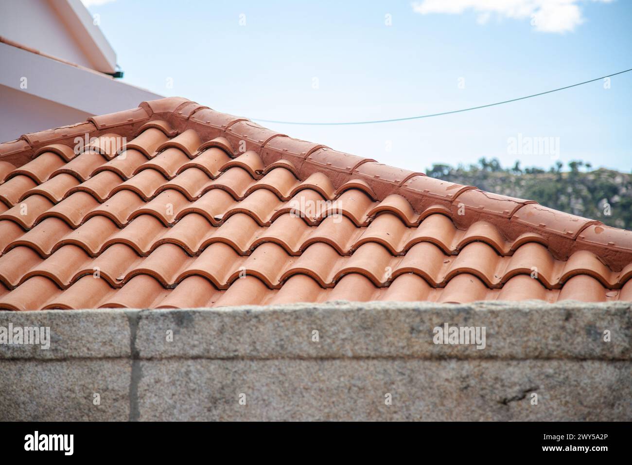 Piastrelle arancioni allineate su un tetto con dettagli in pietra. Copia spazio Foto Stock