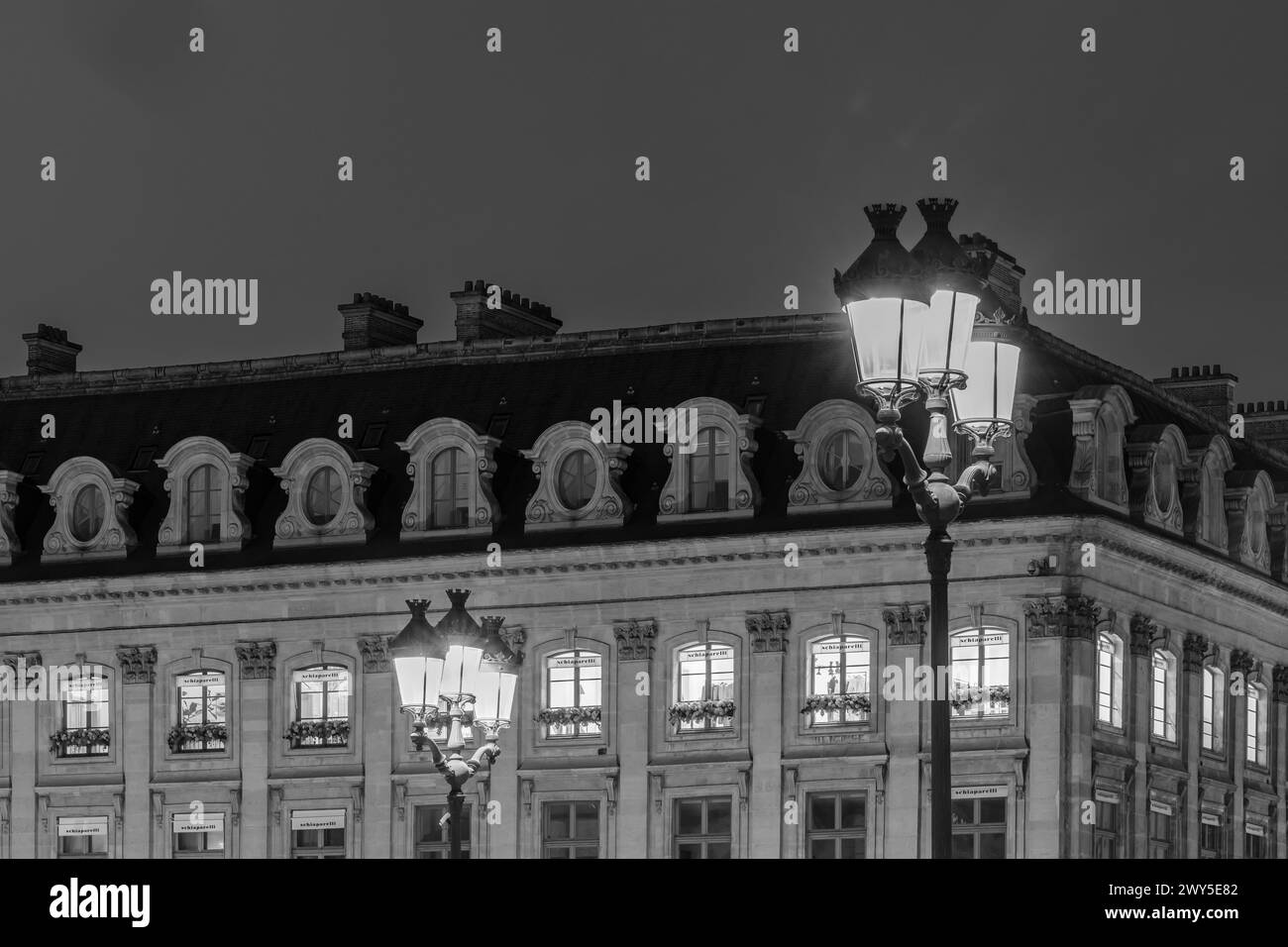 Parigi, Francia - 17 febbraio 2024: Vista dei lampioni illuminati in Place Vendôme con i suoi negozi e hotel di lusso a Parigi in Francia Foto Stock