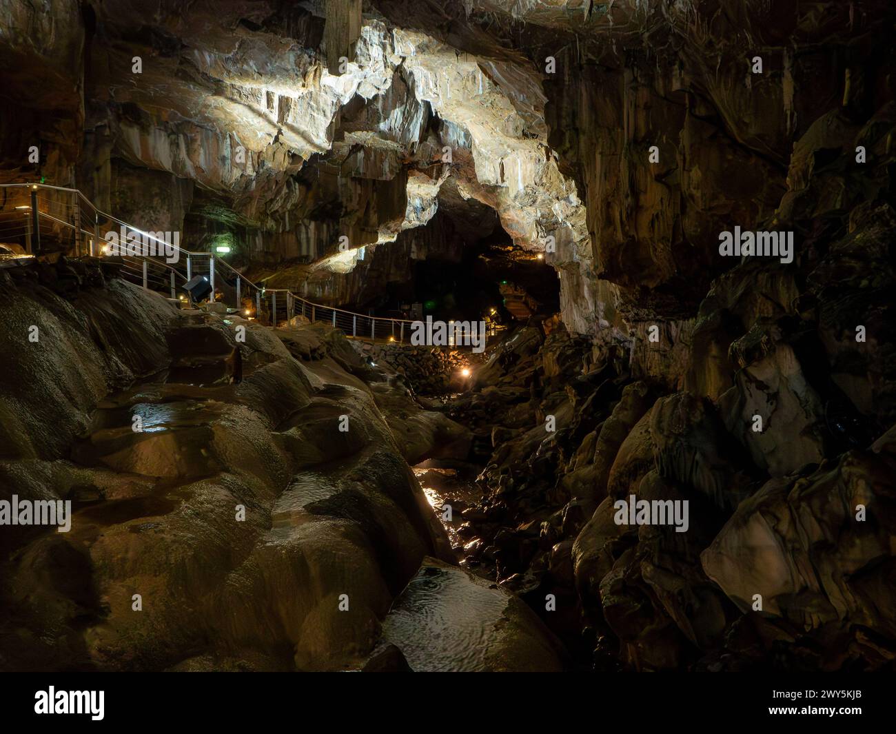 Percorso lungo il lato del fiume sotterraneo nella Poole's Cavern Derbyshire Foto Stock