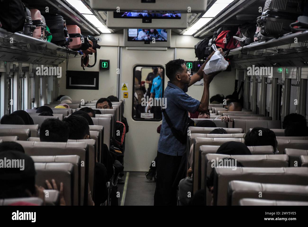 I passeggeri organizzano i loro bagagli nella cabina del treno prima della celebrazione Eid al-fitr 1445 Hijriah alla stazione ferroviaria di Kiaracondong, Bandung, Giava Ovest, Indonesia, il 4 marzo 2024. Milioni di persone stanno iniziando a partire per tornare nelle loro città natale. La tradizione di tornare a casa (mudik), che viene solitamente praticata dai musulmani indonesiani prima di Eid al-Fitr, è diventata ormai una parte importante della cultura e anche le persone approfittano di questo momento di ritorno a casa per riunirsi con i parenti nella loro città natale. (Foto di Dimas Rachmatsyah/Sipa USA) Foto Stock