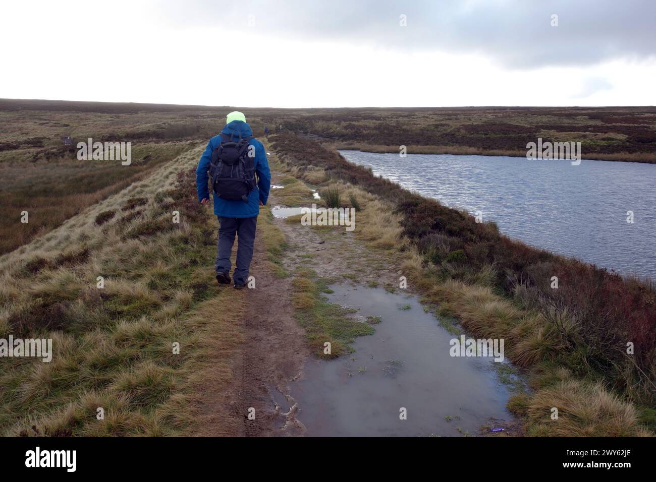 Man (escursionista) camminando sul muro della diga dell'High Lanshaw Reservoir a Burley/Ilkley Moor nel Yorkshire Dales National Park, Inghilterra, Regno Unito Foto Stock