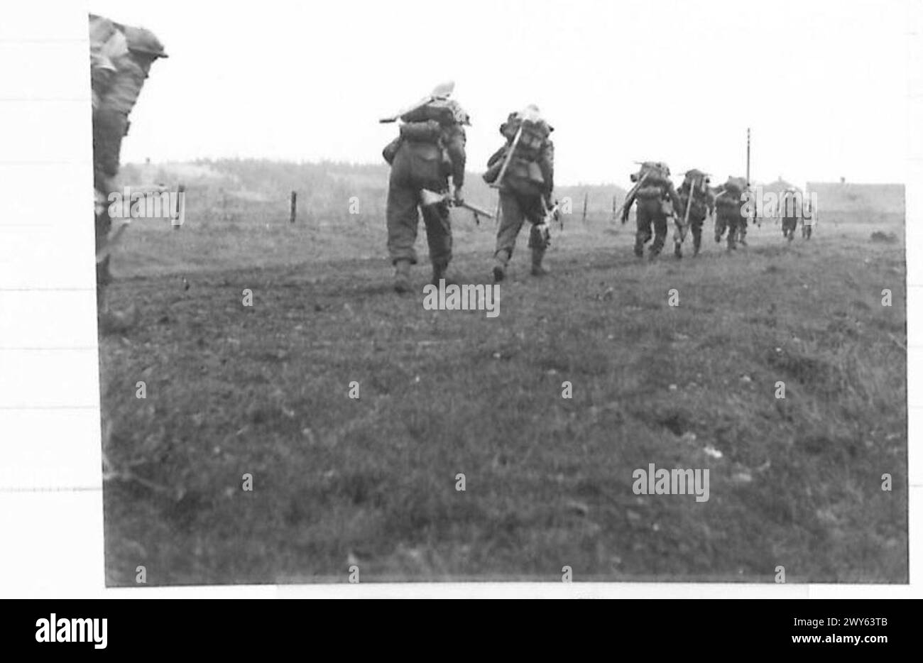 La fanteria britannica accovacciò e avanzò rapidamente lungo una strada verso Venraij nei Paesi Bassi durante le operazioni di combattimento. Foto Stock