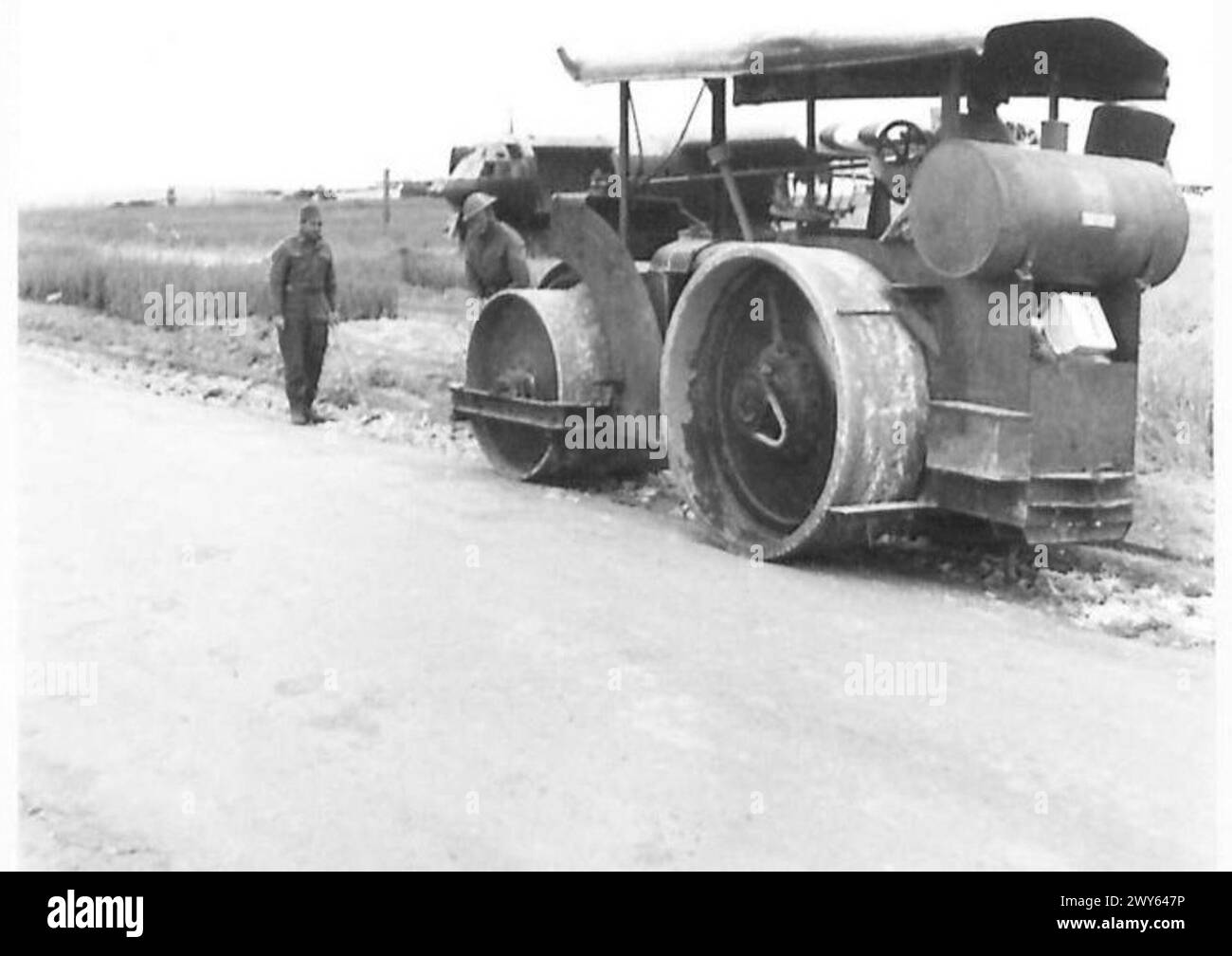 NORMANDIA VARIE - molti lavori sono stati fatti dai Royal Engineers per ampliare e migliorare le strade. Qui sono al lavoro con il loro rullo. Sullo sfondo c'è uno degli alianti utilizzati per sbarcare le truppe fuori Colleville. , British Army, 21st Army Group Foto Stock