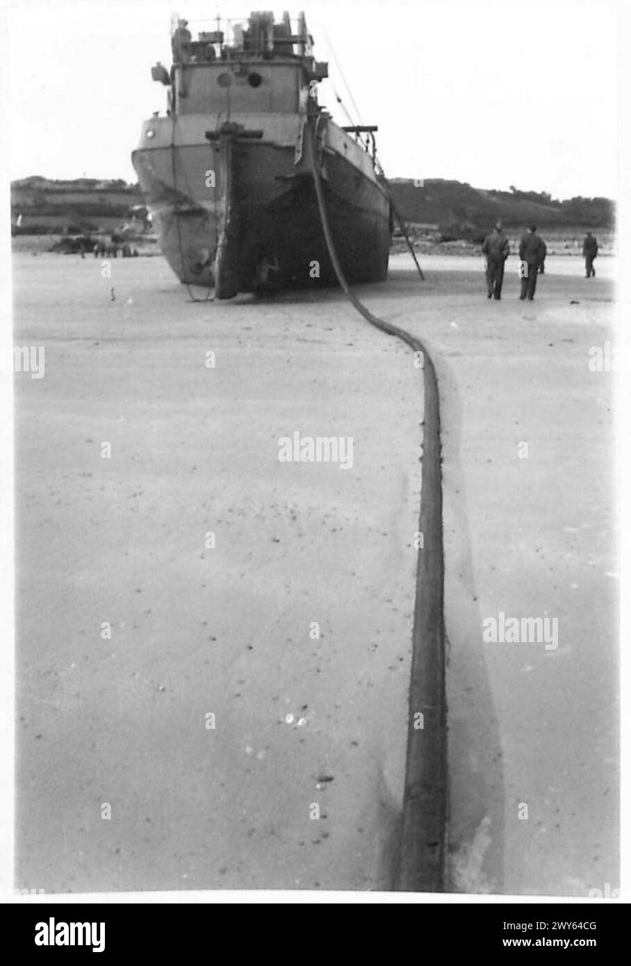 Un tubo sotto la Manica è collegato a una nave sulla spiaggia di Cherbourg, pronta ad essere collegata alla linea di rifornimento terrestre, facilitando il trasferimento di combustibile e risorse. Foto Stock