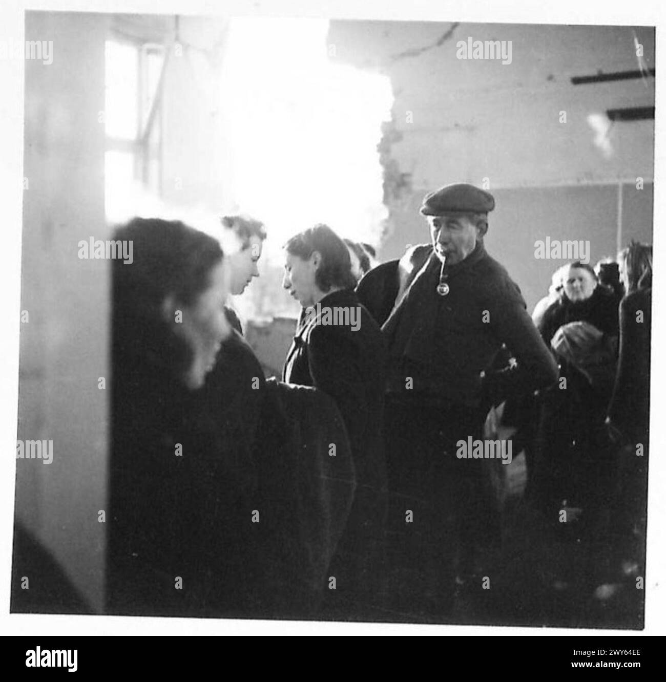 All'interno di una stanza con un buco a conchiglia mostra la distribuzione di abbigliamento alleato per civili olandesi sotto la supervisione del 21st Army Group dell'esercito britannico, 1945. Foto Stock