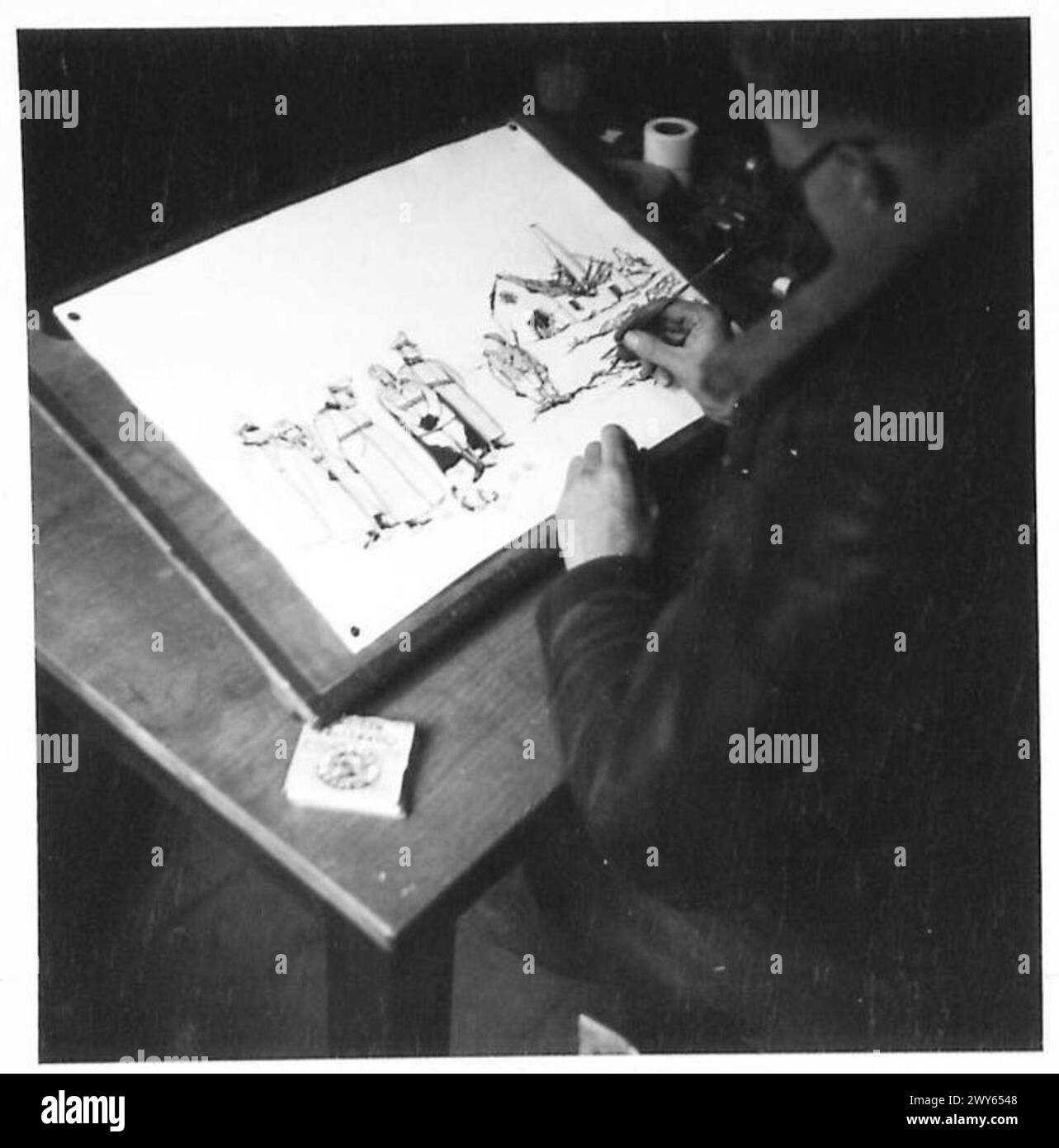 Giles è mostrato in una stanza tranquilla in Germania completando un cartone animato, documentato dall'esercito britannico, 21st Army Group. Foto Stock